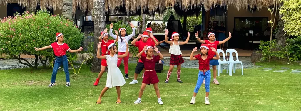 Atmosphere Soup Kitchen children wearing Santa hats and performing Christmas carols at Atmosphere Resorts & Spa