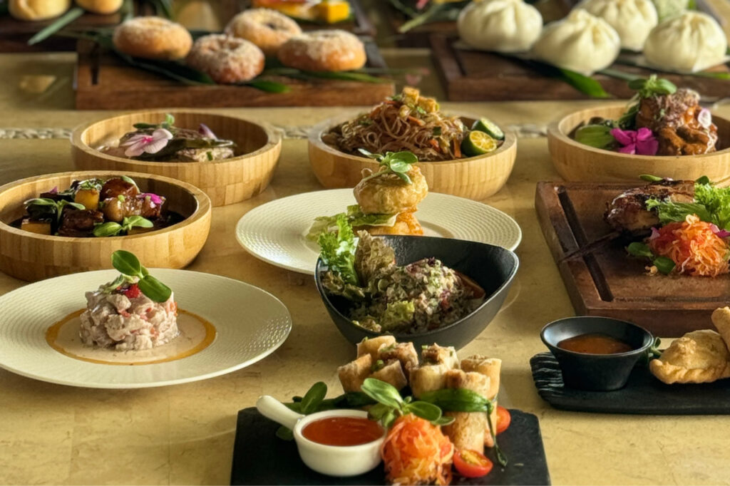 A colorful spread of Filipino dishes beautifully plated at Atmosphere Resorts & Spa, featuring adobo, lumpia, pancit, and other local specialties.