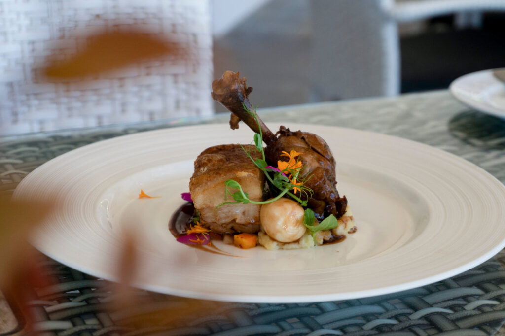 A plated serving of Atmosphere Pork and Chicken Adobo topped with chicharon crust, stuffed chicken leg, and quail egg at Atmosphere Resorts & Spa.