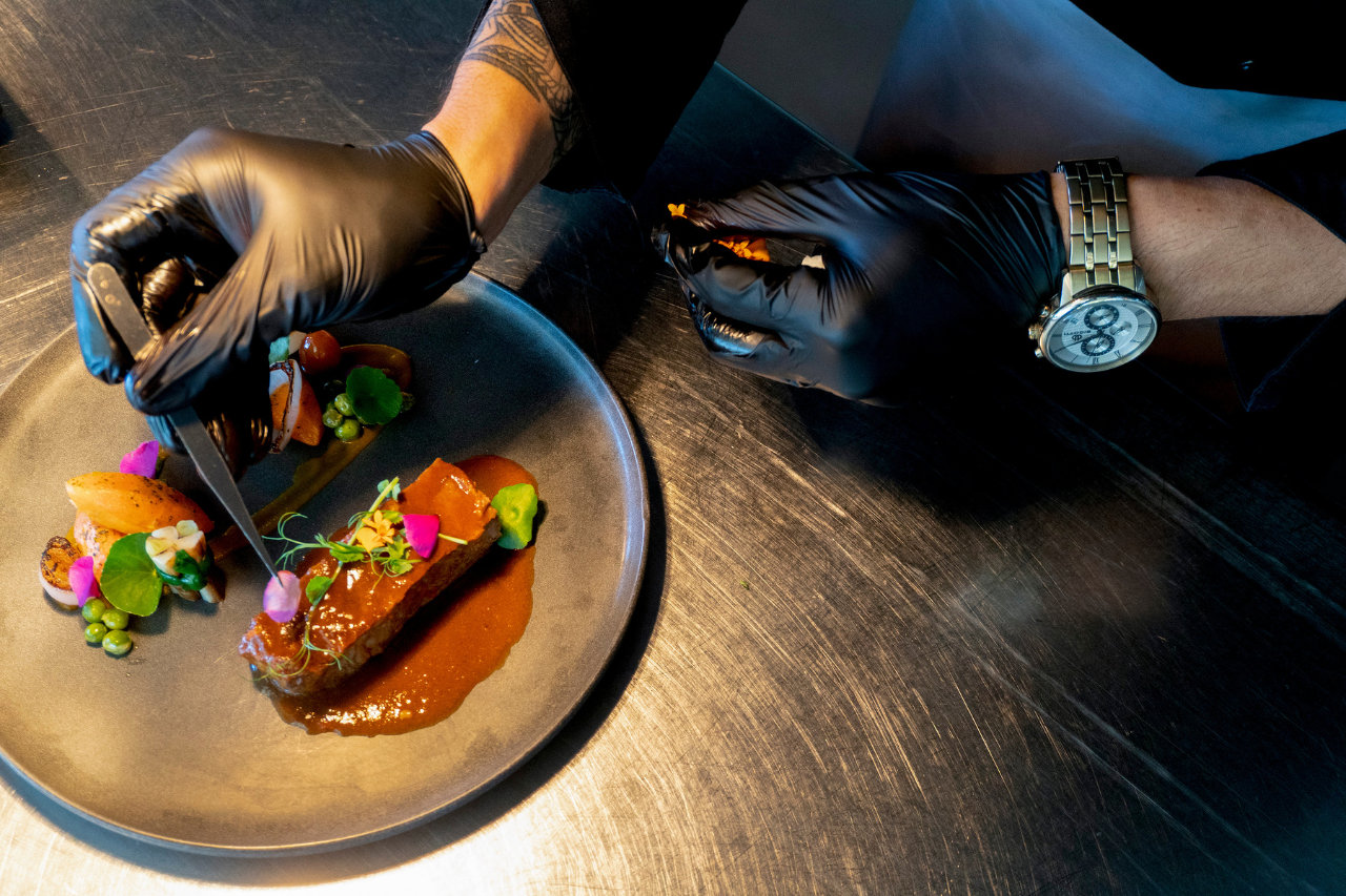 Chef Jun Tubog delicately plating Angus short ribs caldereta with colorful microgreens and sauce at Atmosphere Resorts & Spa.