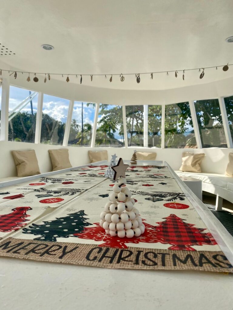 Festive Christmas table setting aboard the Victoria dive boat at Atmosphere Resorts & Spa, decorated for the holiday season.