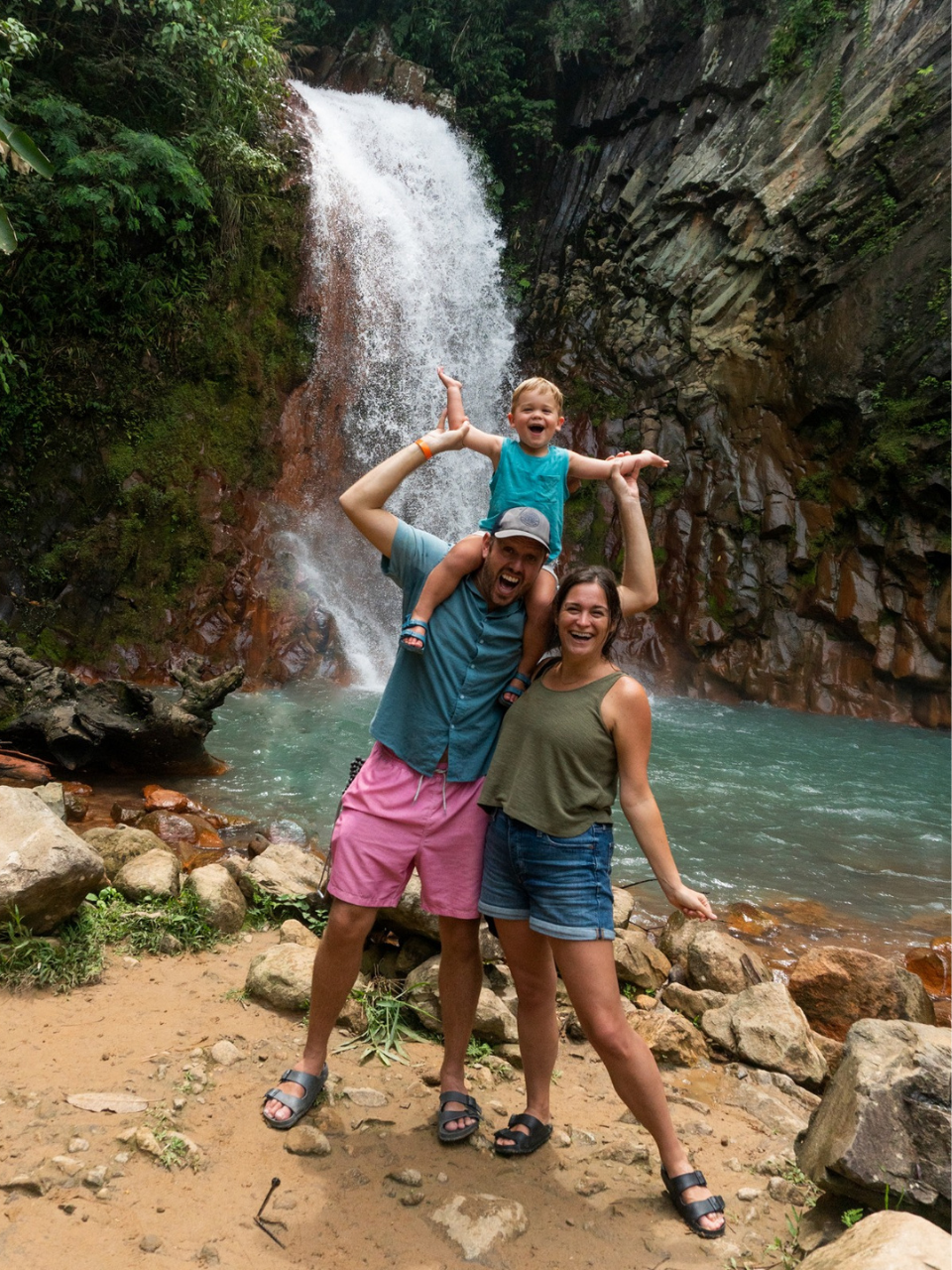 Family posing in front of Pulang Bato Falls in Negros Oriental, Philippines