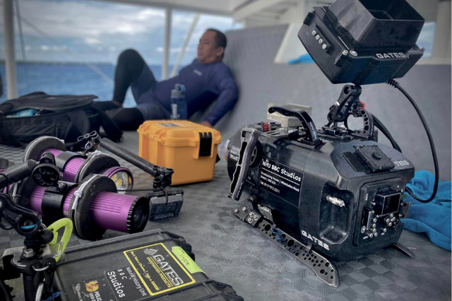 Professional underwater filming equipment and BBC Studios camera gear arranged on a dive boat during filming preparations in Dauin.