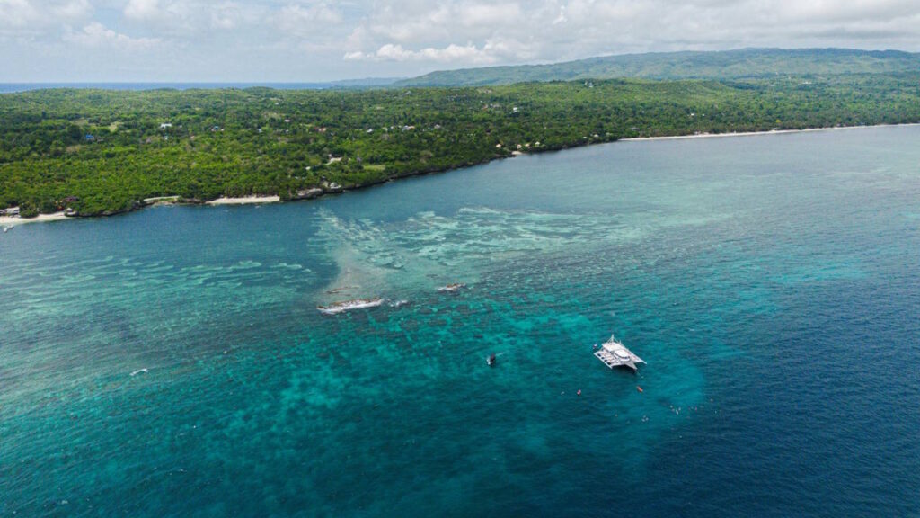Islands fringed by coral reefs and beaches Drone view of Siquijor Island with pristine reefs and marine sanctuaries