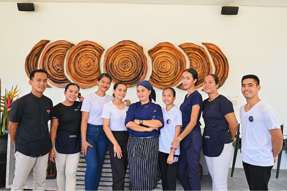 A few members of the Food & Beverage team at Atmosphere Resorts & Spa poses together inside The Breeze Restaurant, showcasing the people behind the resort’s dining and guest service experience.