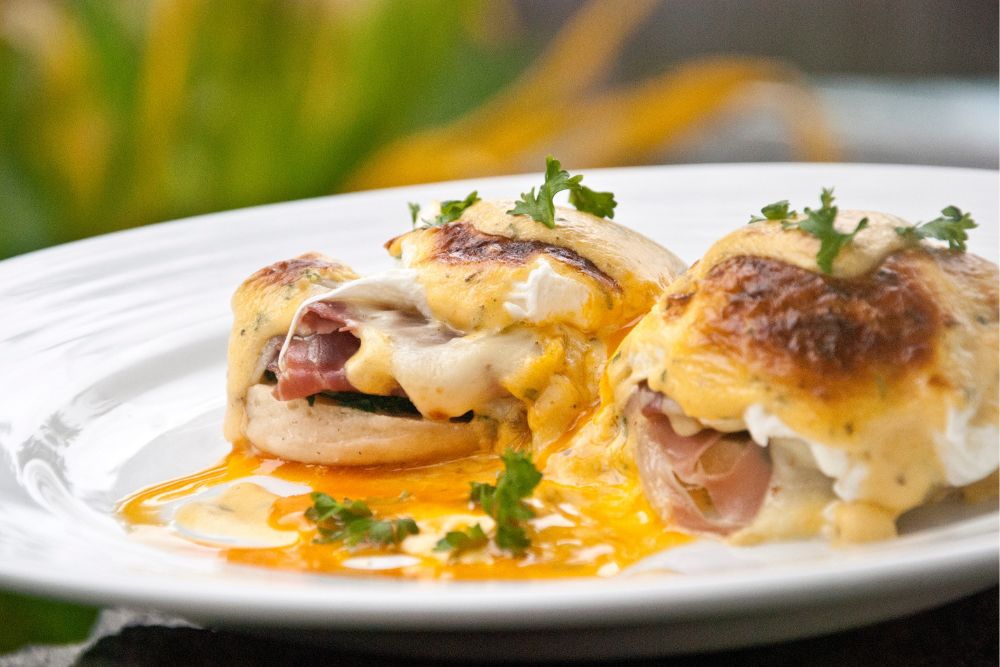 Classic Eggs Benedict served with poached eggs, ham, and hollandaise sauce on toasted English muffins at Atmosphere Resorts & Spa.