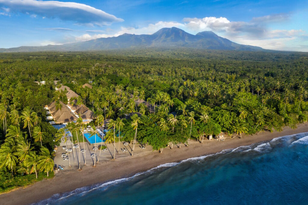 Aerial view of Atmosphere Resorts & Spa with Mount Talinis and the Dauin coastline, Negros Oriental, Philippines.