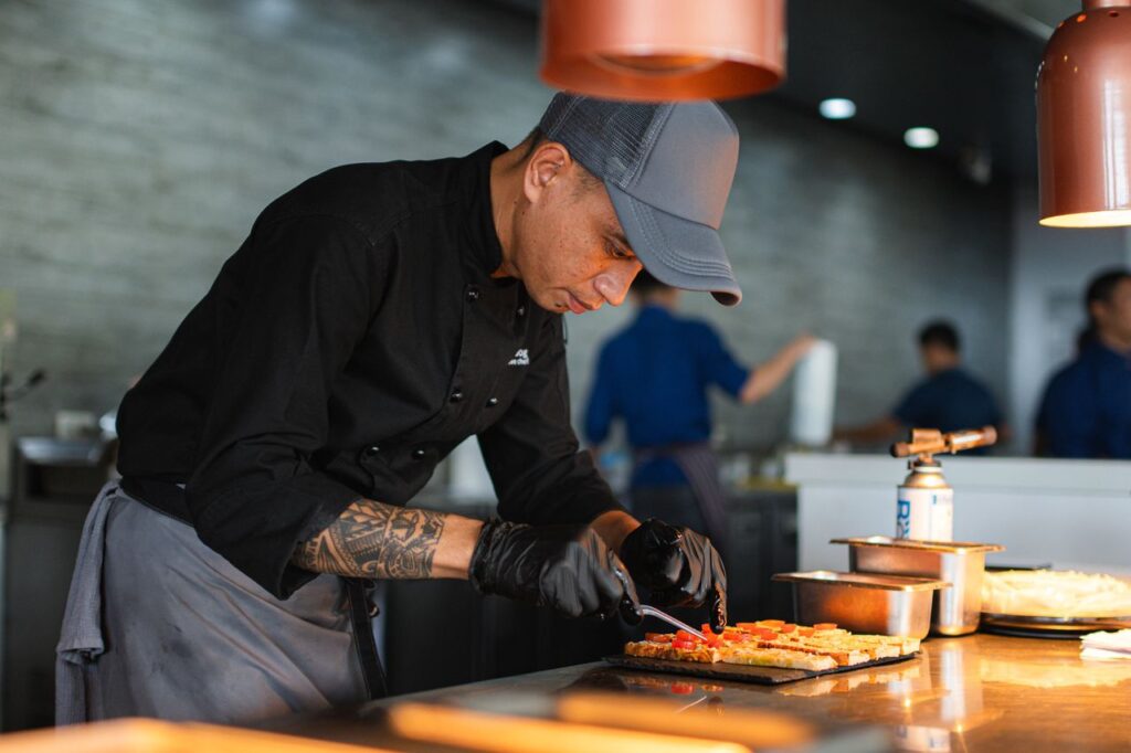 Chef Jun preparing food in the professional kitchen at Atmosphere Resorts & Spa