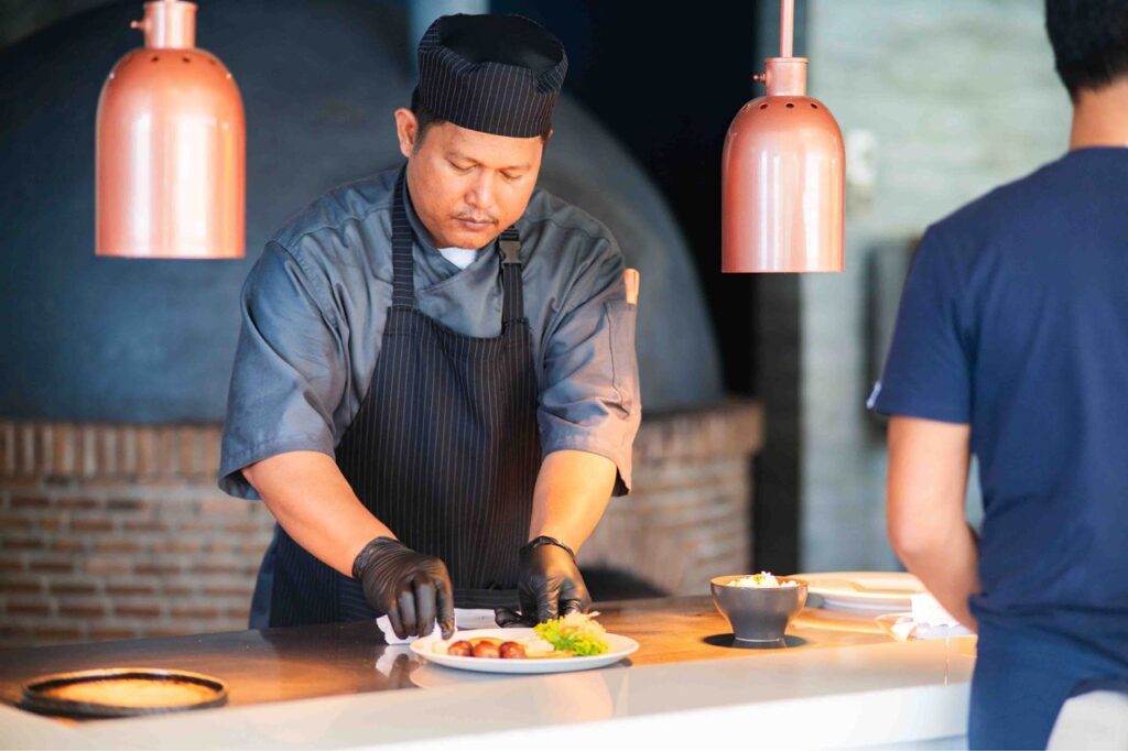 Chef plating a dish at Atmosphere Resorts & Spa