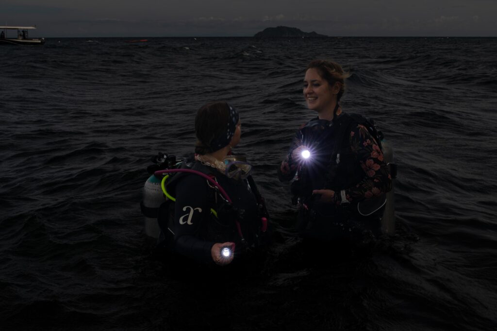 Two divers preparing for a night dive in dauin