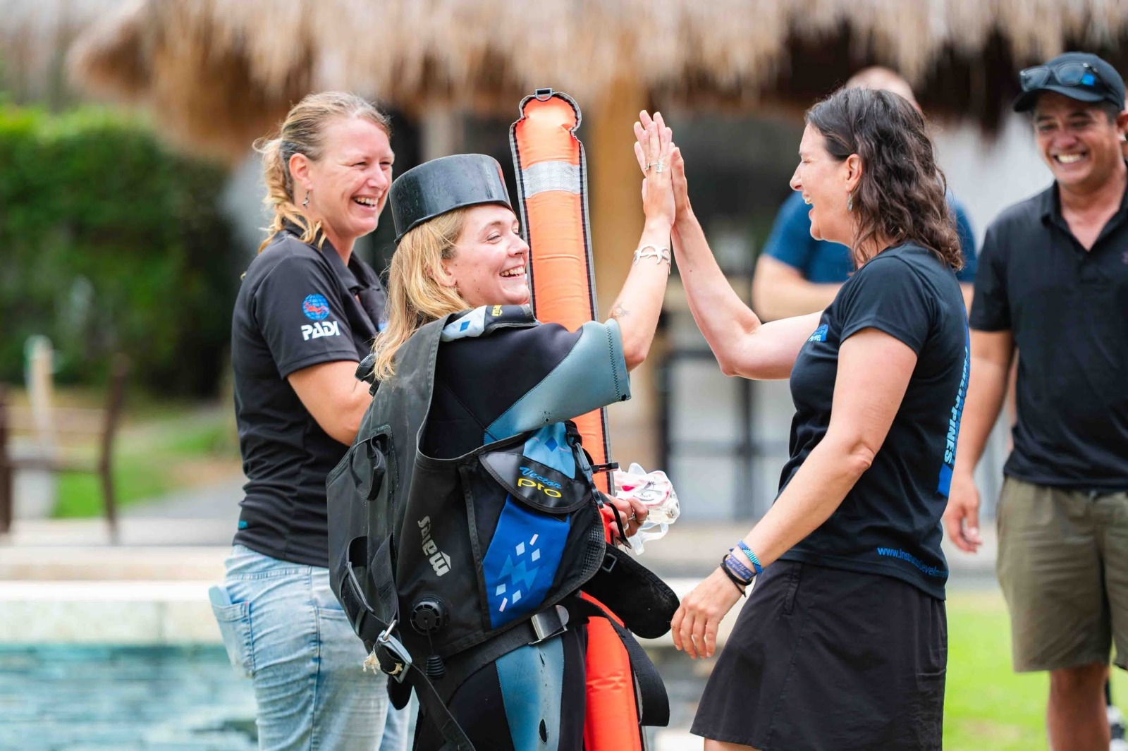 PADI Course Director Berlinda celebrating with an IDC student after a practical training session at Atmosphere Resorts & Spa