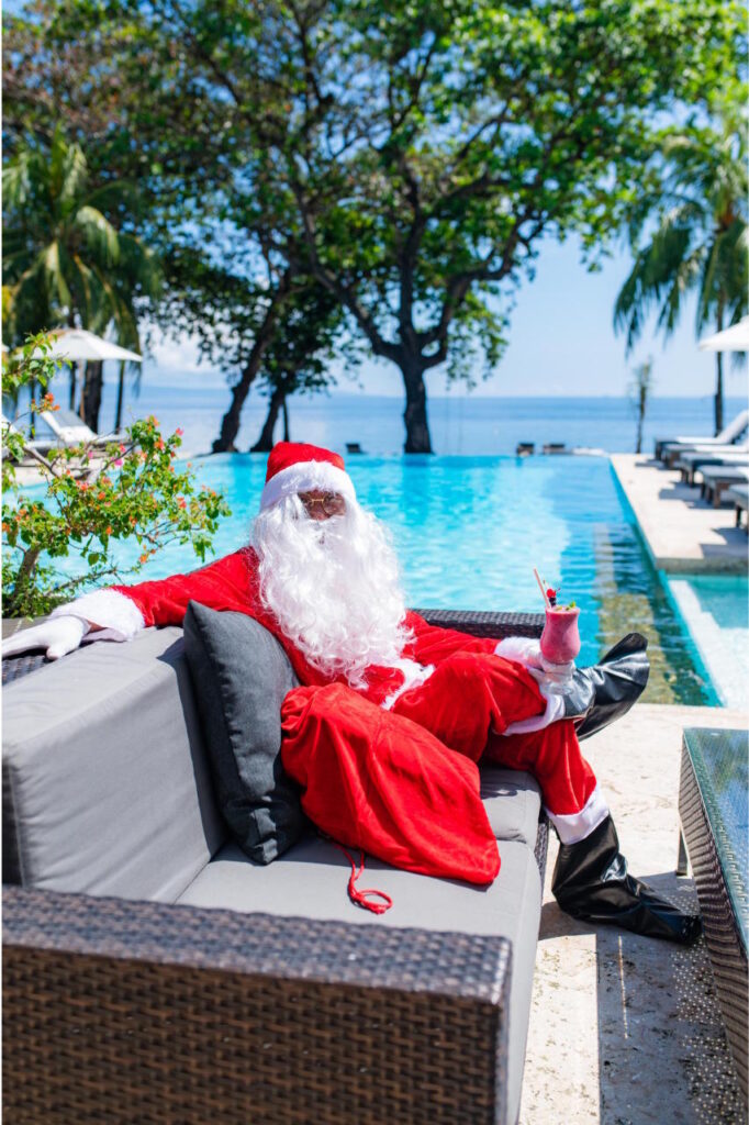 Santa Claus relaxing on a sun lounger beside the infinity pool at Atmosphere Resorts & Spa in Dauin